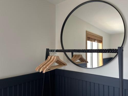 a round mirror on a wall next to a bathroom at Pinedale Cozy Cabins in Pinedale