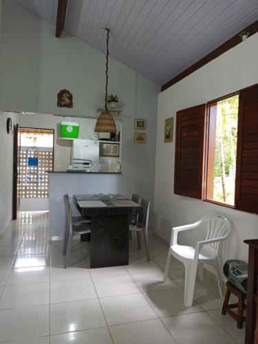 een keuken en eetkamer met een tafel en stoelen bij Sítio Recanto Feliz - Pertinho da Igrejinha in Praia dos Carneiros