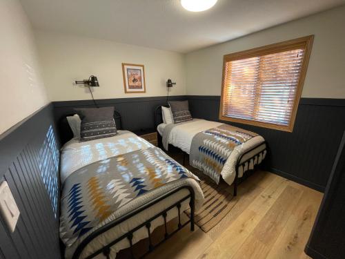 a bedroom with two beds and a window at Pinedale Cozy Cabins in Pinedale