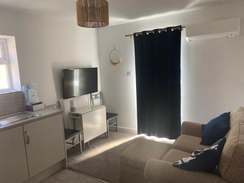 a living room with a couch and a kitchen at Cosy one bed central Fareham in Fareham