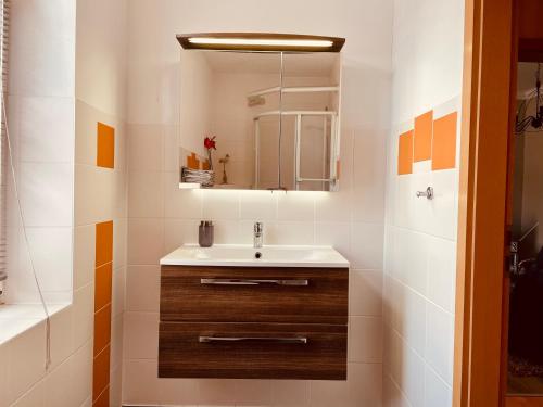 ein Bad mit einem Waschbecken und einem Spiegel in der Unterkunft Haus Burmeister in Sassnitz