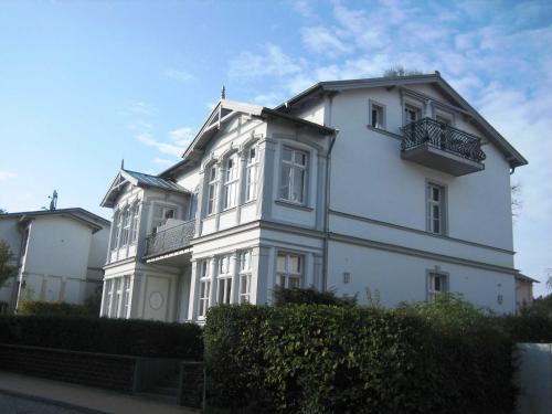 Villa Baroni nur 200m vom Ostseestrand entfernt في بانسين: مبنى أبيض مع شرفة على جانبه