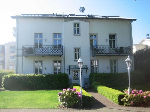 uma grande casa branca com flores em frente em Villa Baroni nur 200m vom Ostseestrand entfernt em Bansin