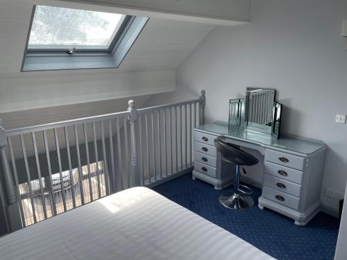 a bedroom with a bed and a desk and a crib at Littleover Lodge Hotel in Derby