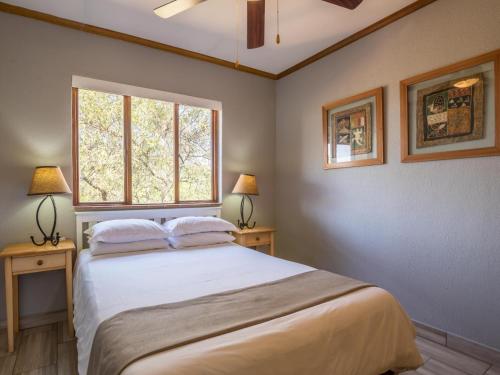 a bedroom with a large bed with two tables and a window at Greenway Woods Accommodation in White River