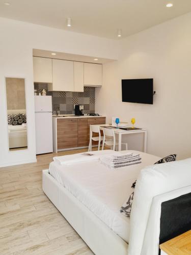 a living room with a white couch and a kitchen at BARBARA Classy Apartments 103, Wellness in Siracusa
