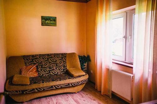 un sofá en una habitación con ventana en Domek letniskowy w leśnym zaciszu en Węgorzewo