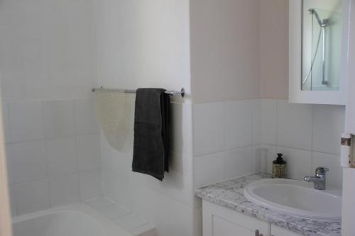 a white bathroom with a sink and a mirror at H5 Goose Valley Golf Estate in Plettenberg Bay