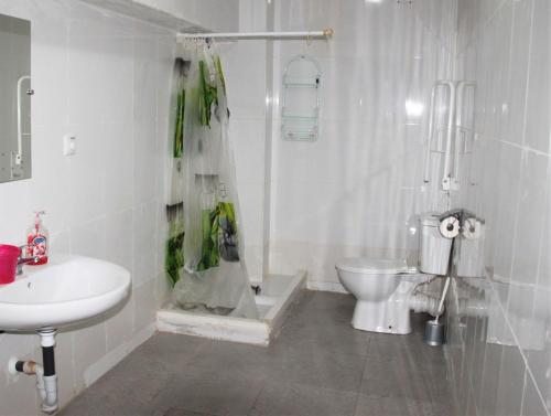 Baño blanco con aseo y lavamanos en Pension La Lambra Azul en Alicante