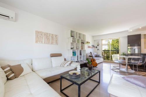 a living room with a white couch and a table at Ideal congress and vacation LIVE IN VILLA PARADOR in Cannes
