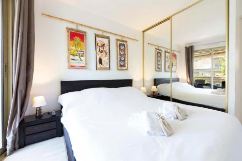 1 Schlafzimmer mit 2 Betten und einem großen Spiegel in der Unterkunft Ideal congress and vacation LIVE IN VILLA PARADOR in Cannes