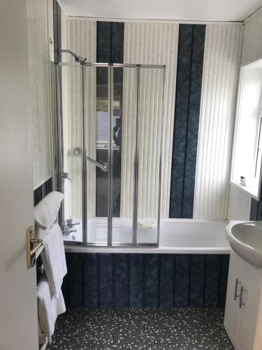 uma casa de banho com um chuveiro, uma banheira e um lavatório. em Kielty's of Kerry Bed and Breakfast em Waterville