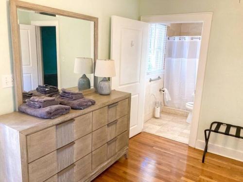 a room with a dresser with a mirror and a bathroom at University House - 8 Bedrooms Walk to UF / Stadium in Gainesville