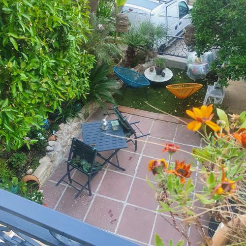 Elle offre une vue sur la terrasse dotée de 2 chaises et de fleurs. dans l'établissement And&Col Jardin ,terrasse & climatisation, à Marseille