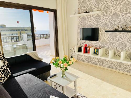 a living room with a couch and a tv at Ocean Park II in Adeje