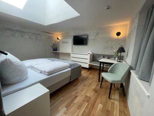 a bedroom with a bed and a desk and a tv at Boutique Hotel Hardthaus in Kraiburg am Inn