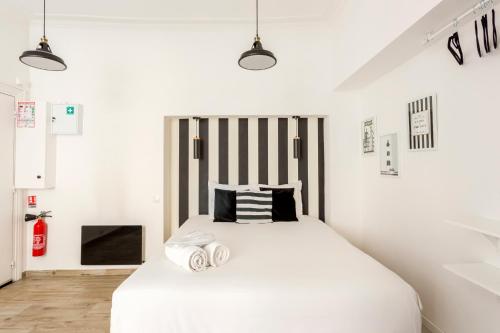 a bedroom with a white bed with two towels on it at Edwin Suites in Paris
