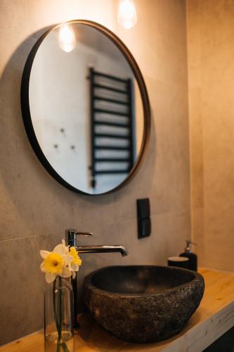 a bathroom with a stone sink and a mirror at Domki Momenty in Słajszewo