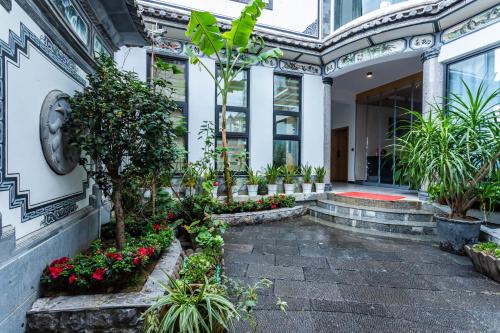 a building with plants and flowers in a courtyard at Blue Sea Hotel in Dali