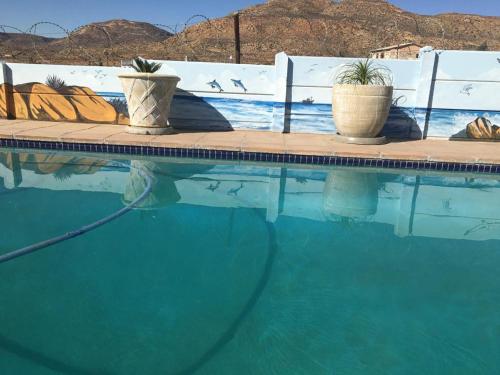 a swimming pool with two potted plants next to it at Home Sweet Home in Springbok
