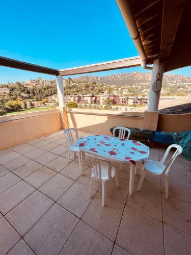 un patio avec une table et des chaises sur un balcon dans l'établissement Spacieux Appartement Climatisé  Dernier étage, à Agay