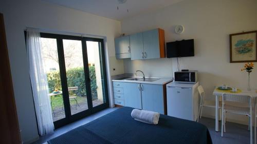 a small kitchen with a door open to a balcony at Nel villaggio il Monolocale tra gli ulivi in SantʼAndrea Apostolo dello Ionio