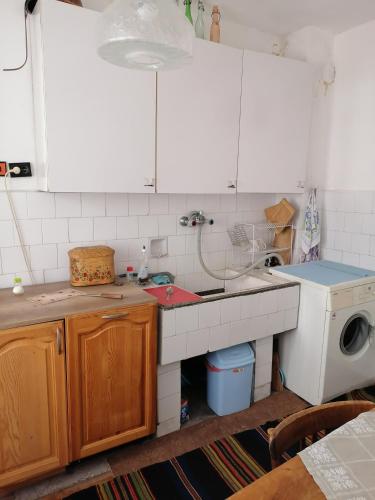 a kitchen with a sink and a washing machine at Емил in Velingrad