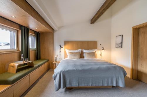 Un dormitorio con una cama grande y dos ventanas. en Goldbrunn, en Oberstdorf
