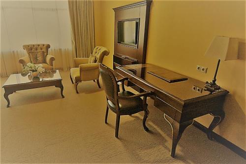 a room with a desk and a chair and a table at Hotel Monec in Ankara