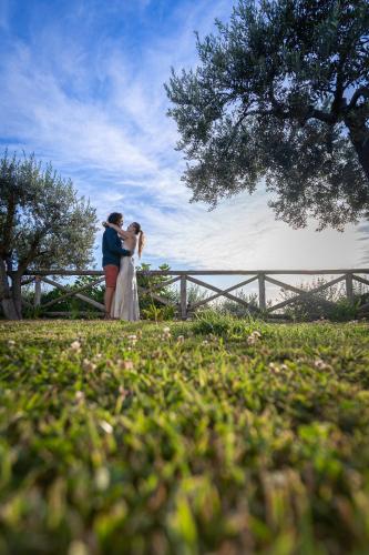 a bride and groom kissing in front of a fence at Casa Clementina Marciano in Massa Lubrense