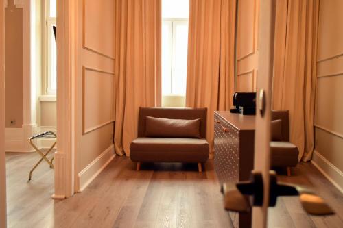 a living room with a chair and a window at Arte Nova Guesthouse in Covilhã