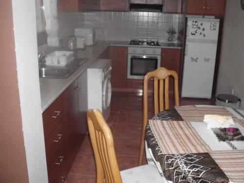 a kitchen with a table and a white refrigerator at anastasia holiday apartments in Paphos City