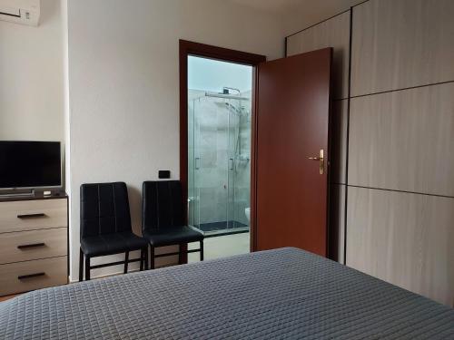 a bedroom with two chairs and a bed and a television at B&B Villa Martina in Sardara