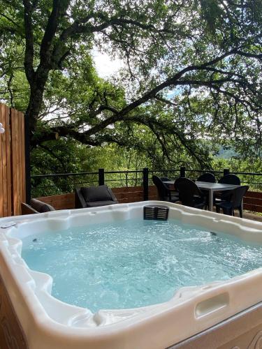a hot tub on a patio with a table and chairs at Le Mas de la Grenouillère in Joyeuse