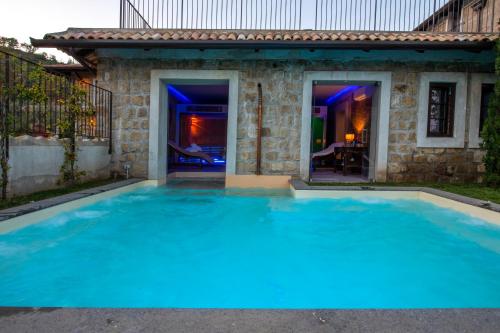 a large blue swimming pool in front of a house at Masseria del Carmine Maggiore 1817 in Pozzuoli