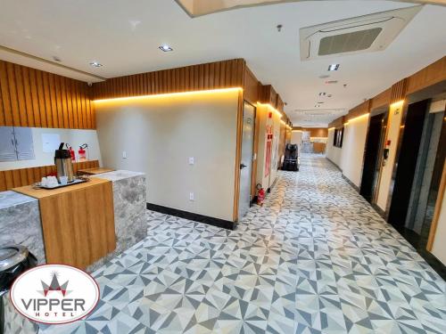 a hallway in a hotel with a tile floor at VIPPER Hotel in Aparecida