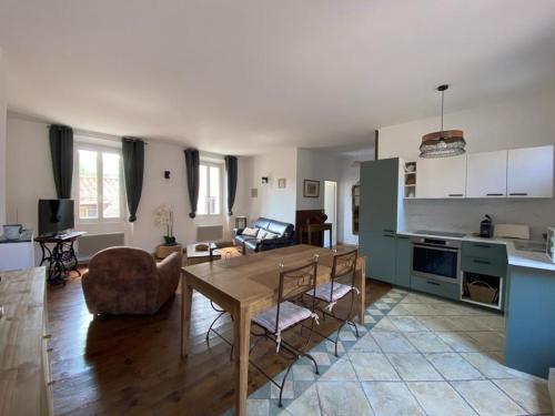 a kitchen and living room with a table and a couch at La Maison Des Vendangeurs in Villesèque-des-Corbières