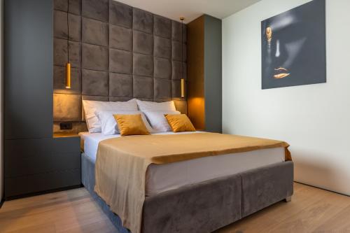 ein Schlafzimmer mit einem großen Bett mit einem großen Kopfteil in der Unterkunft Lux Apartments Marko in Baška Voda
