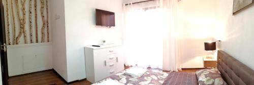 a bedroom with a bed and a dresser and a window at Pensiunea Timiș in Borşa