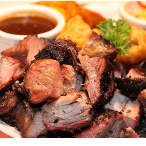 a plate of food with meat and dipping sauce at Caribbean estate deluxe 2 in Portmore