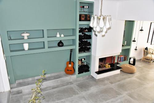 a living room with a blue wall with a fireplace at Virginia Rooms in Olympiaki Akti