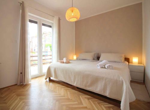 1 dormitorio con 1 cama con sábanas blancas y ventana en Apartments in Porec/Istrien 9923, en Poreč