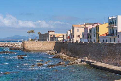 a river with houses and buildings on a beach at Palau Marco Polo in Alghero
