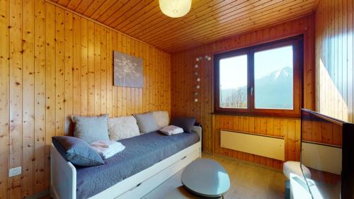 ein Schlafzimmer mit einem Bett in einer Holzwand in der Unterkunft Charming chalet with a splendid view of the Valais mountains 