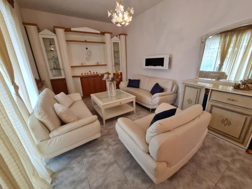 a living room with white chairs and a table at Myrtia Guest House in Pýrgos