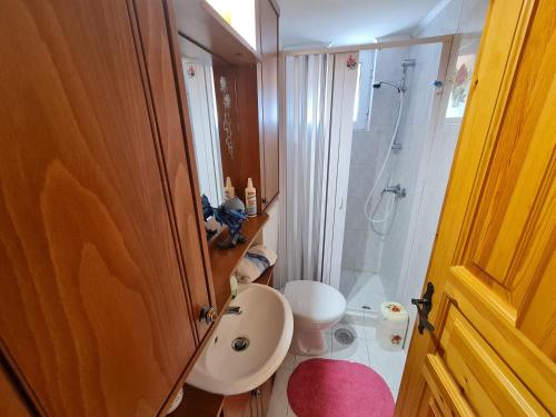 a bathroom with a toilet and a sink and a shower at Myrtia Guest House in Pýrgos