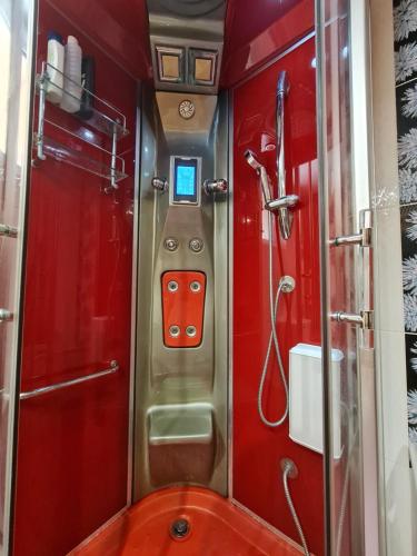 a red bathroom with a shower and a toilet at Myrtia Guest House in Pýrgos