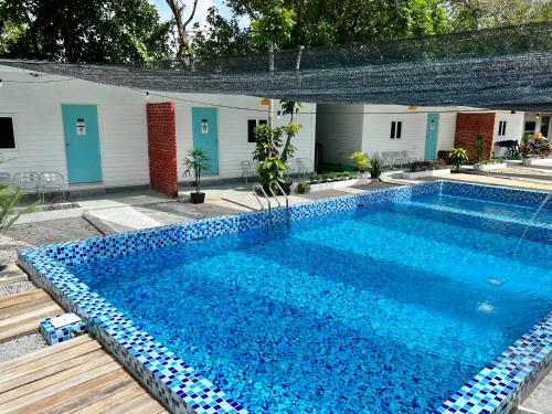 a large blue swimming pool next to a building at Bertam Cottage Penang in Kepala Batas