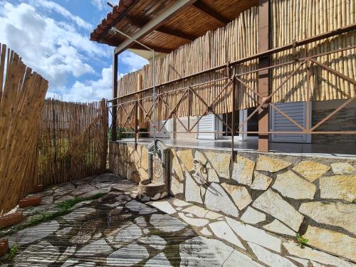 a building with a wooden fence and a stone wall at Myrtia Guest House in Pýrgos