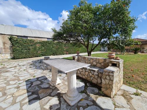 a stone table sitting on top of a stone wall at Myrtia Guest House in Pýrgos
